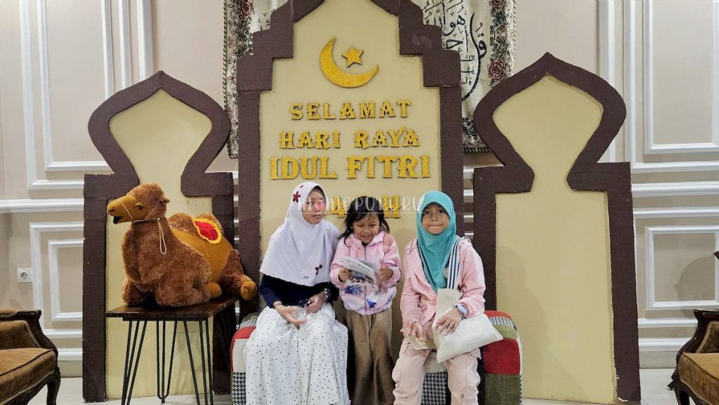 Anak-anak berfoto di sebelah unta