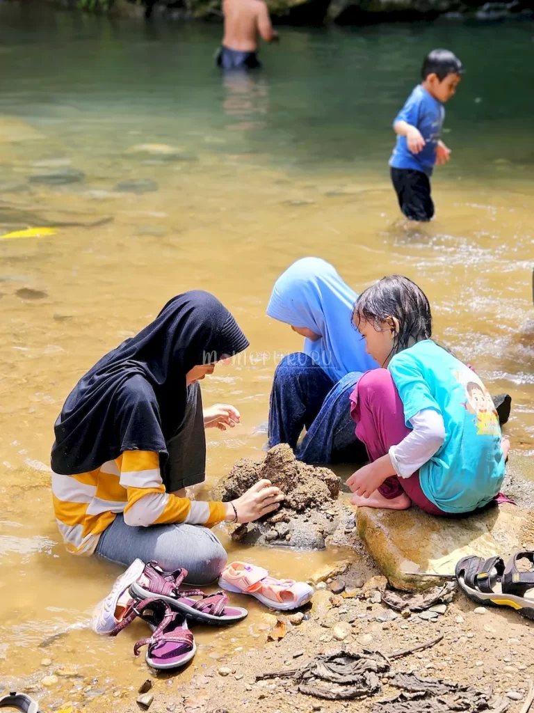 Anak-anak main pasir di pinggir sungai