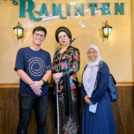 Berfoto dengan patung Raminten