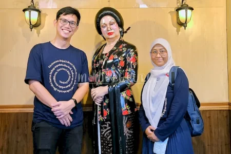 Berfoto dengan patung Raminten